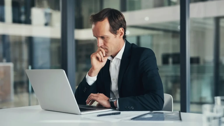 Thinking businessman on a laptop