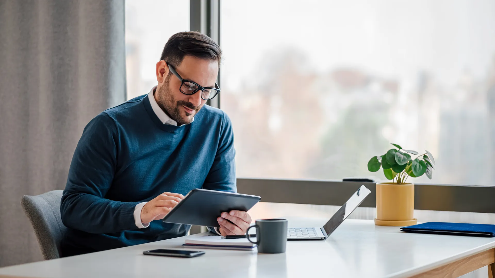 Mortgage broker on tablet and laptop